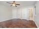 Unfurnished bedroom with dark wood floors, a ceiling fan, and double closets at 100 Longneedle Ct, Raleigh, NC 27603