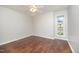 A bright, unfurnished bedroom showcases dark wood flooring and a ceiling fan at 100 Longneedle Ct, Raleigh, NC 27603
