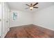 A bright, unfurnished bedroom showcases dark wood flooring and a ceiling fan at 100 Longneedle Ct, Raleigh, NC 27603