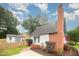 Charming exterior featuring a brick chimney, well-maintained lawn, and tasteful landscaping at 100 Longneedle Ct, Raleigh, NC 27603