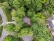 Aerial view of a beautiful house nestled among mature green trees in a quiet, well-kept neighborhood at 1003 Gloucester Ct, Chapel Hill, NC 27516