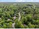 Aerial view showcases the neighborhood surrounded by lush green trees in a serene setting at 1003 Gloucester Ct, Chapel Hill, NC 27516