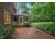 Charming backyard with a brick patio, screened porch, and lush greenery, perfect for outdoor entertaining at 1003 Gloucester Ct, Chapel Hill, NC 27516