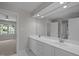 Bathroom featuring dual sinks and a large mirror, with connecting rooms visible at 1003 Gloucester Ct, Chapel Hill, NC 27516