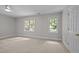 Neutral bedroom with two bright windows and a ceiling fan at 1003 Gloucester Ct, Chapel Hill, NC 27516