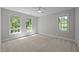 Bright bedroom featuring three windows offering views of mature trees at 1003 Gloucester Ct, Chapel Hill, NC 27516