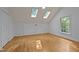 Bright bonus room featuring hardwood floors, two skylights and large windows, offering natural light and spacious feel at 1003 Gloucester Ct, Chapel Hill, NC 27516