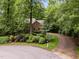 Picturesque front yard with lush greenery, mature trees, and a circular driveway at 1003 Gloucester Ct, Chapel Hill, NC 27516
