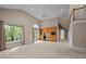 Bright living room featuring carpet, built-in cabinets with a mini fridge, and large windows with outdoor views at 1003 Gloucester Ct, Chapel Hill, NC 27516