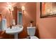 This powder room is decorated with coral colored walls, a round mirror and features a pedestal sink at 1003 Gloucester Ct, Chapel Hill, NC 27516