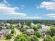 An aerial view of a residential neighborhood with a pond, mature trees and beautiful landscaping at 1008 Wolfs Bane Dr, Apex, NC 27539