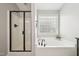 Bathroom with soaking tub, glass enclosed shower, and window at 1008 Wolfs Bane Dr, Apex, NC 27539