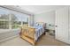Light-filled bedroom with large window, carpet, and wood-framed bed, creating a cozy atmosphere at 1008 Wolfs Bane Dr, Apex, NC 27539