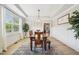 Bright dining room with wooden table, light wood floors, and tray ceiling at 1008 Wolfs Bane Dr, Apex, NC 27539
