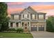 Charming two-story home with brick and tan siding, porch, and manicured lawn at 1008 Wolfs Bane Dr, Apex, NC 27539