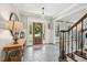Welcoming foyer with tile flooring, staircase, and a view of the front door at 1008 Wolfs Bane Dr, Apex, NC 27539