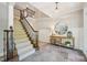 Elegant foyer featuring a carpeted staircase, tile flooring, and decorative table with mirror at 1008 Wolfs Bane Dr, Apex, NC 27539