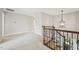 Bright hallway featuring neutral walls, plush carpeting, and a decorative iron-wrought staircase at 1008 Wolfs Bane Dr, Apex, NC 27539
