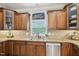 Spacious kitchen featuring wooden cabinets, granite countertops, tile backsplash, and stainless steel dishwasher at 1008 Wolfs Bane Dr, Apex, NC 27539