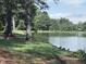 Tranquil lake view with ducks resting by the shoreline and trees behind at 1008 Wolfs Bane Dr, Apex, NC 27539