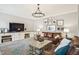 Comfortable living room with leather sofas, a chandelier, and built-in cabinets at 1008 Wolfs Bane Dr, Apex, NC 27539