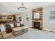 Inviting living room showcasing a stone fireplace, leather sofa, and view into the kitchen at 1008 Wolfs Bane Dr, Apex, NC 27539