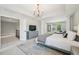 Spacious main bedroom featuring a large bed, sitting area, dresser, and large window at 1008 Wolfs Bane Dr, Apex, NC 27539