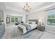 Open main bedroom with tray ceiling, sitting area, chandelier, large windows, and plush carpet at 1008 Wolfs Bane Dr, Apex, NC 27539