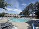 Beautiful community pool with lounge chairs and pergola under a blue sunny sky at 1008 Wolfs Bane Dr, Apex, NC 27539