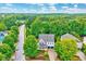 Charming home with a manicured lawn and a two-car garage showcased from an aerial view with surrounding lush greenery at 101 Ironcreek Pl, Apex, NC 27539