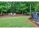 Private backyard with a fire pit area, lush greenery, and space for recreation at 101 Ironcreek Pl, Apex, NC 27539