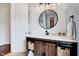 Stylish bathroom featuring a rustic wood vanity, a modern round mirror, and a bright white color palette at 101 Ironcreek Pl, Apex, NC 27539