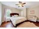 Comfortable bedroom with a plush bed, a cozy sofa, and hardwood floors, illuminated by natural light at 101 Ironcreek Pl, Apex, NC 27539