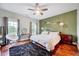 Bright bedroom with large windows, a decorative ceiling fan, and neutral decor on hardwood floors at 101 Ironcreek Pl, Apex, NC 27539