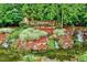 Beautiful Woodcreek community entrance with lush landscaping, waterfall, and stone signage at 101 Ironcreek Pl, Apex, NC 27539