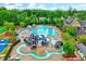 Aerial view of a community pool area featuring slides, lazy river, seating, and mature trees at 101 Ironcreek Pl, Apex, NC 27539