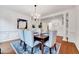 Formal dining room featuring elegant wainscoting, hardwood floors, and a stylish chandelier above the table at 101 Ironcreek Pl, Apex, NC 27539