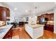 Open-concept kitchen with island, granite countertops, stainless steel appliances, and hardwood floors at 101 Ironcreek Pl, Apex, NC 27539