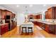 Spacious kitchen with granite countertops, stainless steel appliances, a large island, and rich wooden cabinetry at 101 Ironcreek Pl, Apex, NC 27539