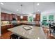 Spacious kitchen featuring a large granite island, stainless steel appliances, and stylish pendant lighting at 101 Ironcreek Pl, Apex, NC 27539
