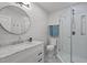 Stylish bathroom with white marble vanity, round mirror, and glass-enclosed shower at 1015 Watts St, Durham, NC 27701