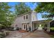 Charming grey two-story home with a covered carport, brick steps, and beautifully landscaped yard with mature trees at 1015 Watts St, Durham, NC 27701