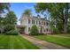 Two-story home with a well-maintained lawn, covered carport, and traditional architectural style at 1015 Watts St, Durham, NC 27701