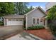 Charming grey home with a two-car garage, well-maintained landscaping, and brick-lined driveway offering excellent curb appeal at 1015 Watts St, Durham, NC 27701