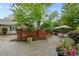 Charming outdoor patio with ample seating, brick accents, lush landscaping, driveway, and a garage, perfect for outdoor living at 1015 Watts St, Durham, NC 27701