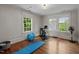Home gym with exercise bike, yoga mat, weights, and natural light from multiple windows at 1015 Watts St, Durham, NC 27701