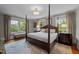 Spacious main bedroom featuring large windows, a four-poster bed, and hardwood floors at 1015 Watts St, Durham, NC 27701