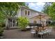 Inviting back patio featuring dining and lounge areas, brick accents, lush landscaping, and a screened-in porch, perfect for outdoor living at 1015 Watts St, Durham, NC 27701