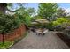 Charming outdoor patio with ample seating, dining area under umbrellas, brick accents and lush greenery, perfect for entertaining at 1015 Watts St, Durham, NC 27701
