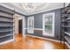 Bedroom with dark gray walls, shelving, and hardwood flooring with a ceiling fan at 105 Houston Cir, Cary, NC 27513